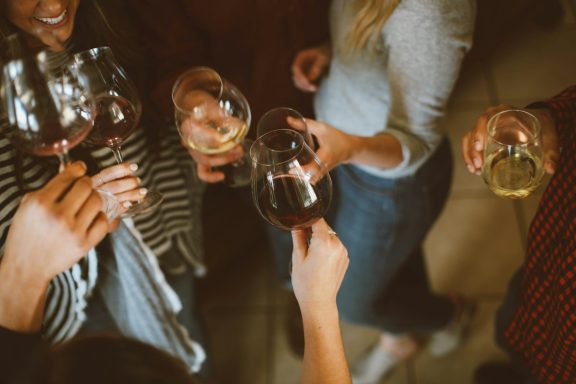 Wine Tasting Celebration Group of guests raising wine glasses for a toast at a celebration event.