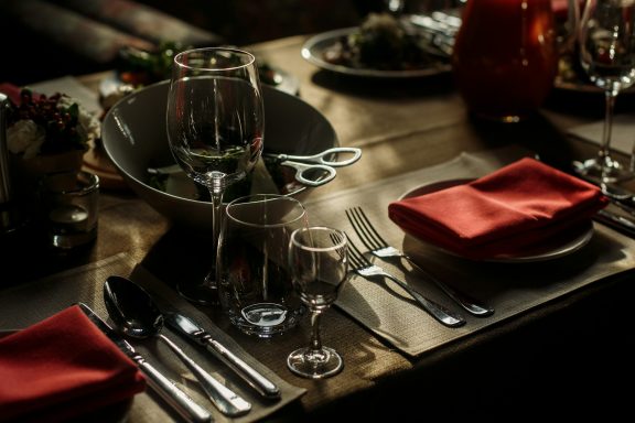 Rustic Wine Event Table Setup Rustic wooden dinner table setup with wine glasses and elegant place settings.
